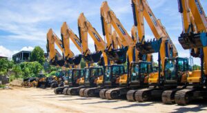 Row of Sany excavators with raised boom arms lined up at Premier Heavy Equipment supplier yard